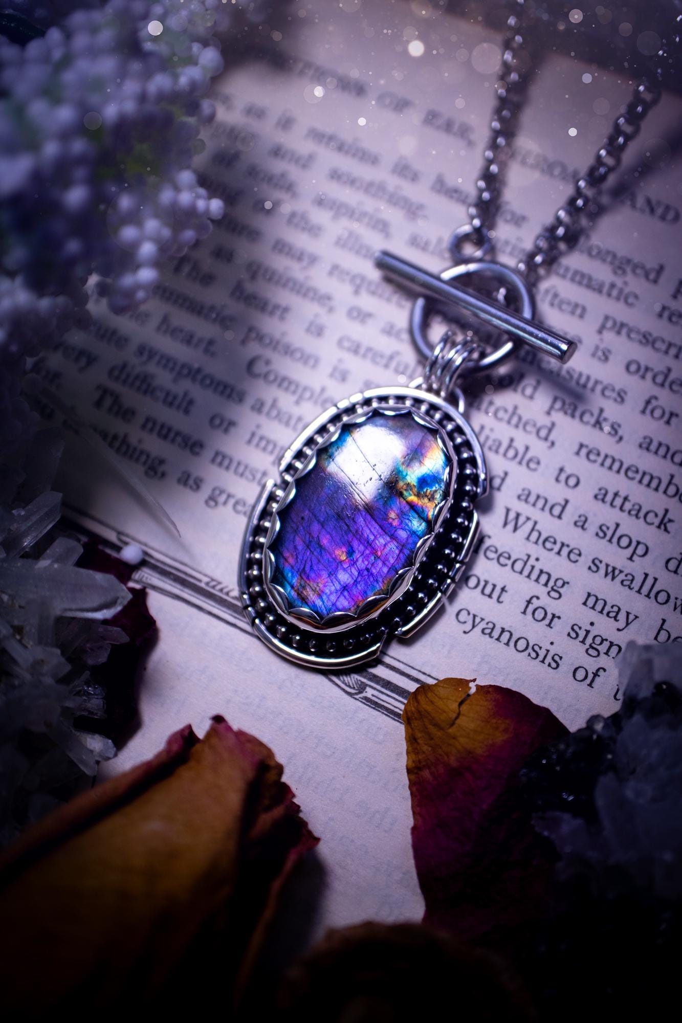 Beautifully handmade, amulet pendant necklace which features the most beautiful rainbow coloured, labradorite spectrolite crystal. This pendant has been handcrafted using a mix of fine and sterling silver. It features a scallop bezel with beaded, and hand carved smooth wire around the stone making this piece totally bespoke and one of a kind. The labradorite has an array of beautiful purples, blues and pinks. This pendant would be suitable for any crystal and jewellery lover, gothic and hippy!