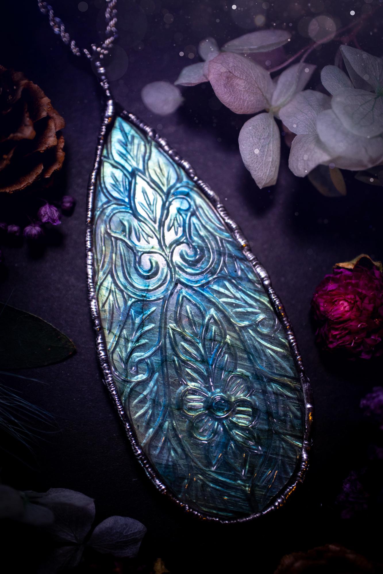 Beautifully handmade and bespoke, carved labradorite, soft soldered pendant necklace. This large labradorite pendant has been crafted using the soft solder method, also known as the tiffany technique. The crystal has a bezel of lead free soft solder which contains small parts of silver that allows for oxidisation and a high lustre polish. This labradorite is full of beautiful blues and greens and has been hand carved with a beautiful floral and leaf pattern. One off, gothic and witchy jewellery
