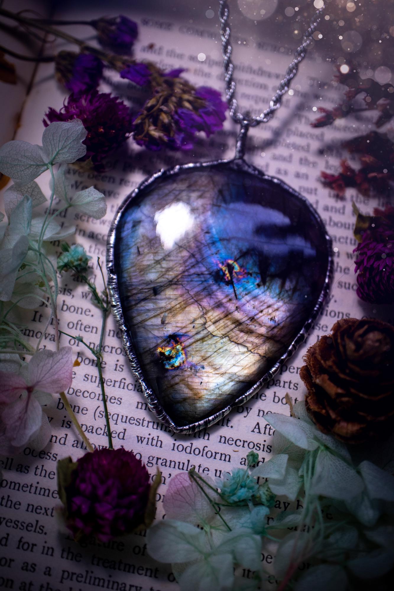 A very unique and one of a kind, soft soldered, labradorite, statement pendant necklace. The labradorite on this pendant is very unique as it is full of silver, purples and blues, with little rainbow clusters. It also has two separate flashing areas on the crystal. Large and beautiful! Handmade using the soft solder method also known as the tiffany technique! This piece of jewellery is a must have for any crystal and jewellery lover, it is full of gothic and witchy vibes! Jewellery for the soul