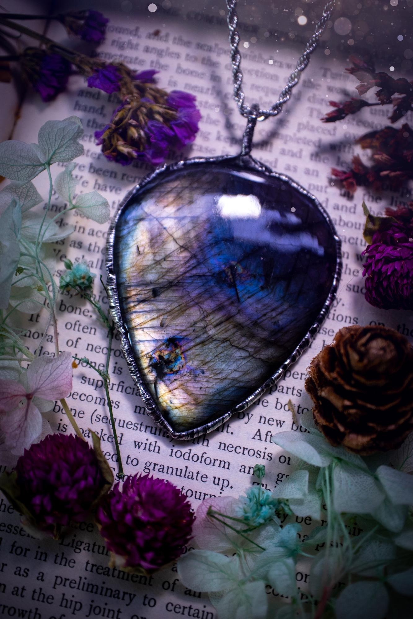 A very unique and one of a kind, soft soldered, labradorite, statement pendant necklace. The labradorite on this pendant is very unique as it is full of silver, purples and blues, with little rainbow clusters. It also has two separate flashing areas on the crystal. Large and beautiful! Handmade using the soft solder method also known as the tiffany technique! This piece of jewellery is a must have for any crystal and jewellery lover, it is full of gothic and witchy vibes! Jewellery for the soul