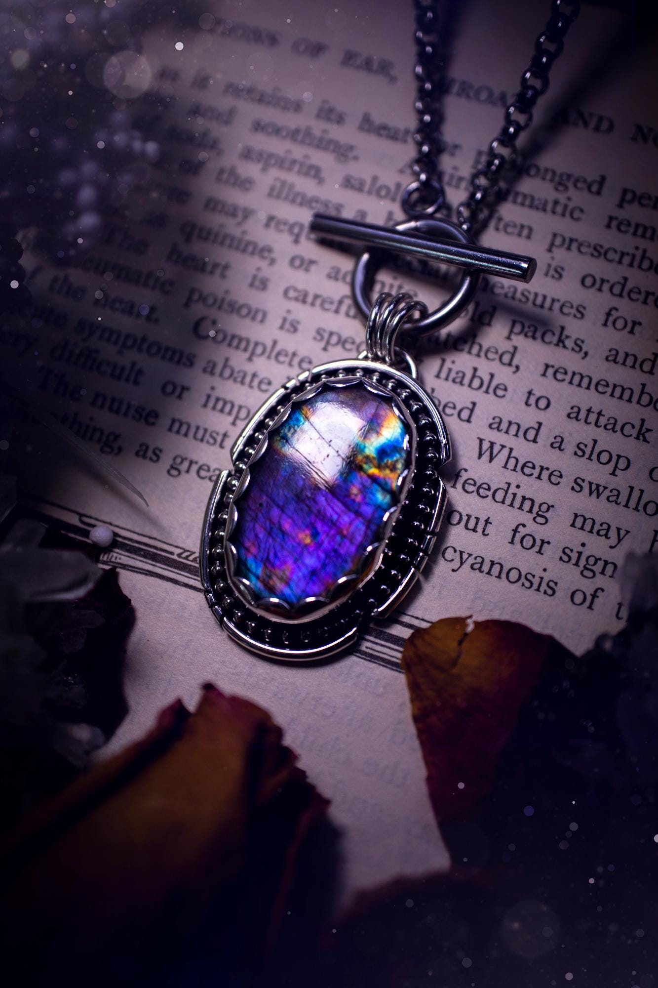 Beautifully handmade, amulet pendant necklace which features the most beautiful rainbow coloured, labradorite spectrolite crystal. This pendant has been handcrafted using a mix of fine and sterling silver. It features a scallop bezel with beaded, and hand carved smooth wire around the stone making this piece totally bespoke and one of a kind. The labradorite has an array of beautiful purples, blues and pinks. This pendant would be suitable for any crystal and jewellery lover, gothic and hippy!