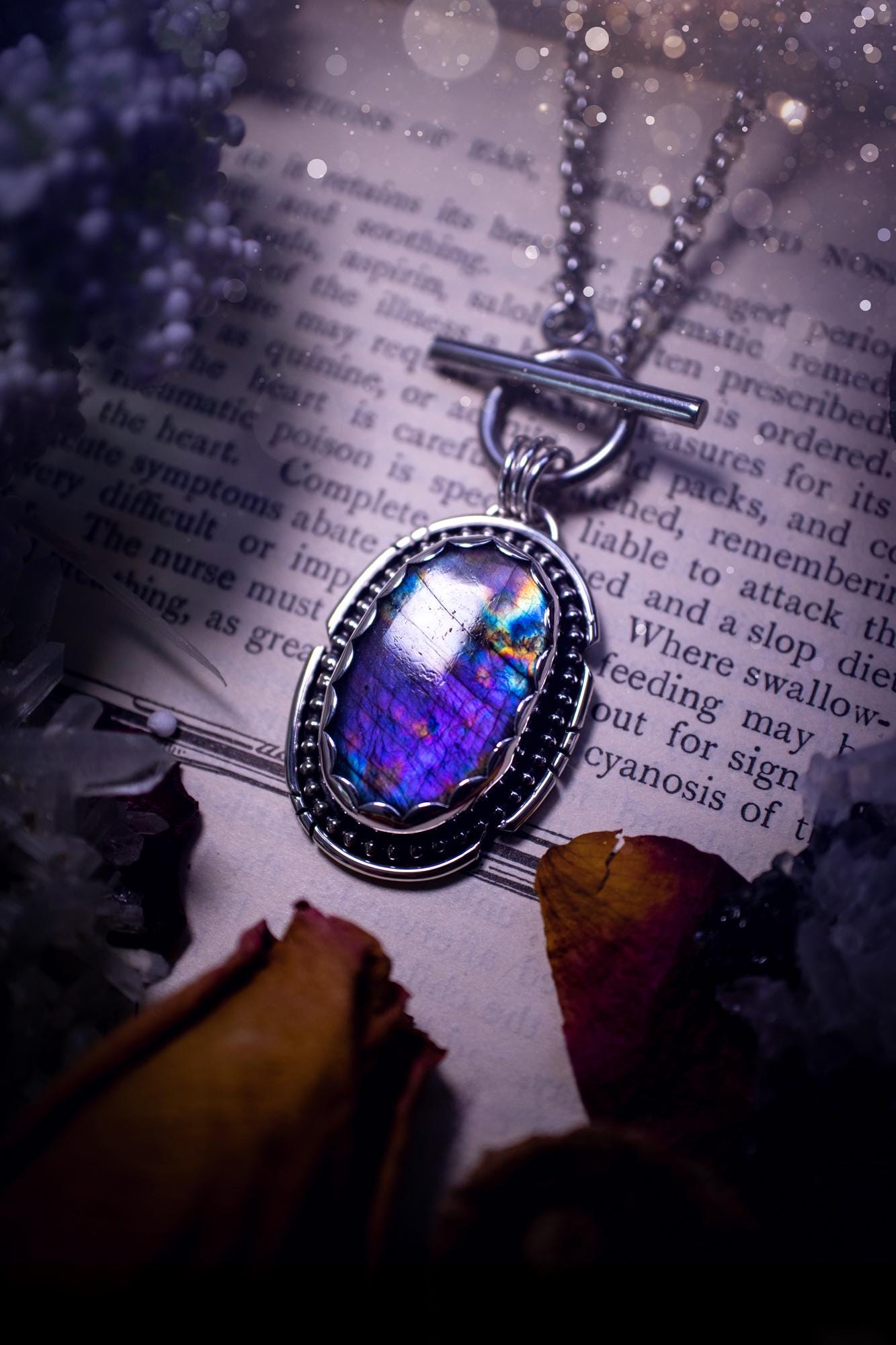 Beautifully handmade, amulet pendant necklace which features the most beautiful rainbow coloured, labradorite spectrolite crystal. This pendant has been handcrafted using a mix of fine and sterling silver. It features a scallop bezel with beaded, and hand carved smooth wire around the stone making this piece totally bespoke and one of a kind. The labradorite has an array of beautiful purples, blues and pinks. This pendant would be suitable for any crystal and jewellery lover, gothic and hippy!