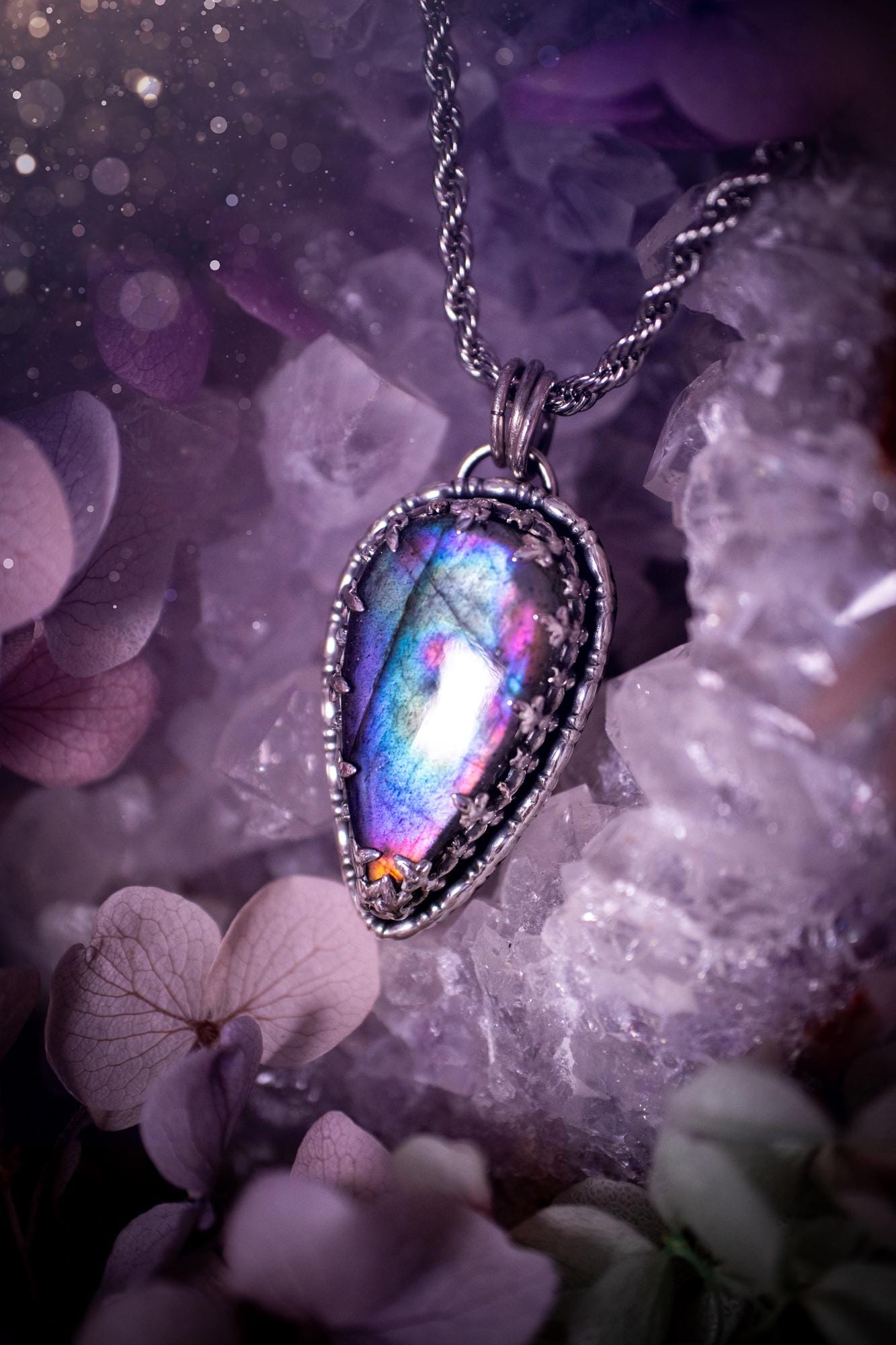 Beautifully handcrafted, rainbow labradorite crystal pendant necklace. This beautiful pendant has been crafted out of sterling and fine silver and features a gothic bezel around the labradorite crystal. The labradorite in this piece is full of beautiful colours, purple, greens, blues with a bit of orange! A really stunning crystal. This jewellery piece would be ideal for anyone who is a fan of jewellery and crystals, and would make the ideal gift. Full of witchy and gothic vibes!