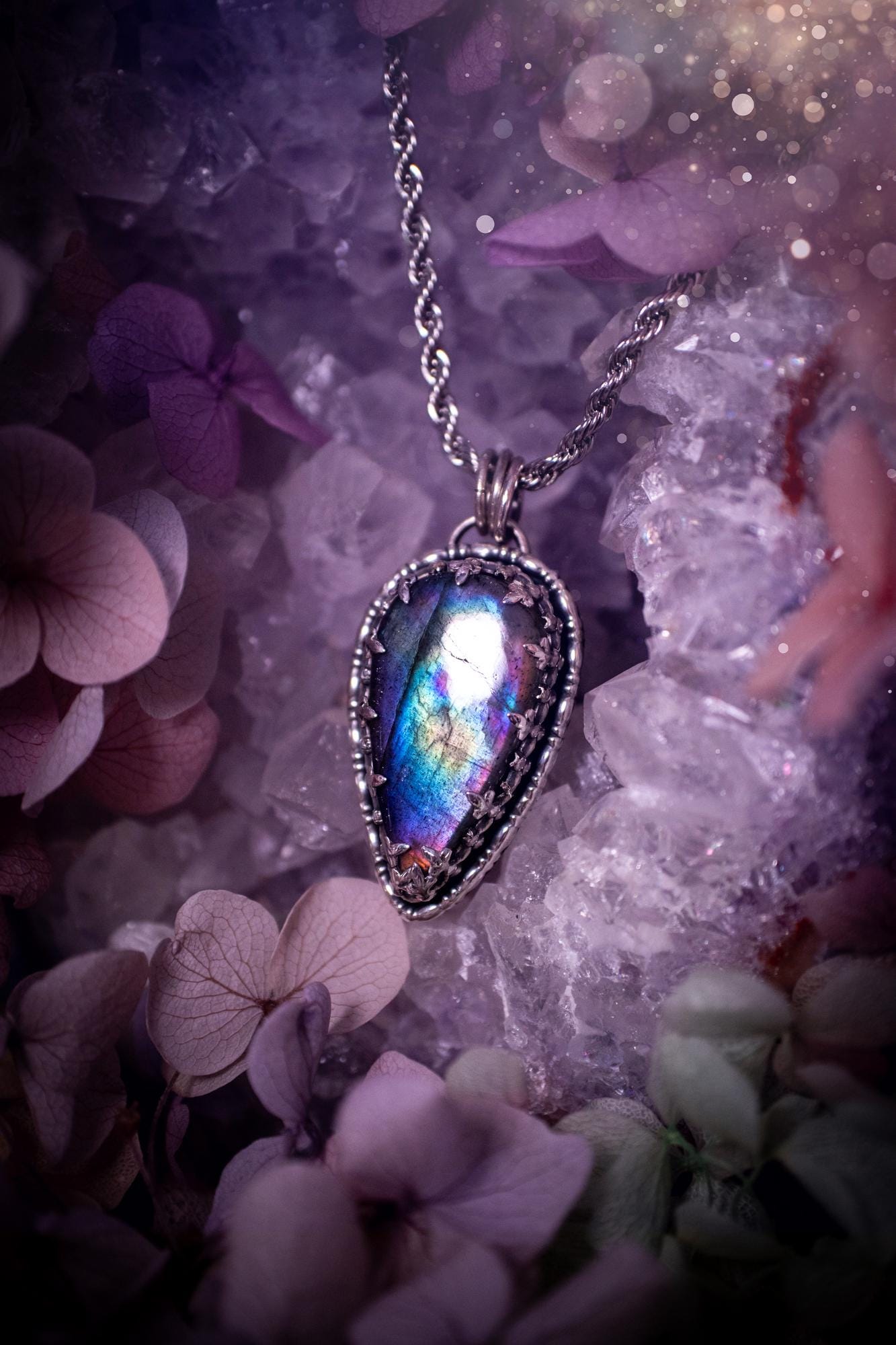 Beautifully handcrafted, rainbow labradorite crystal pendant necklace. This beautiful pendant has been crafted out of sterling and fine silver and features a gothic bezel around the labradorite crystal. The labradorite in this piece is full of beautiful colours, purple, greens, blues with a bit of orange! A really stunning crystal. This jewellery piece would be ideal for anyone who is a fan of jewellery and crystals, and would make the ideal gift. Full of witchy and gothic vibes!