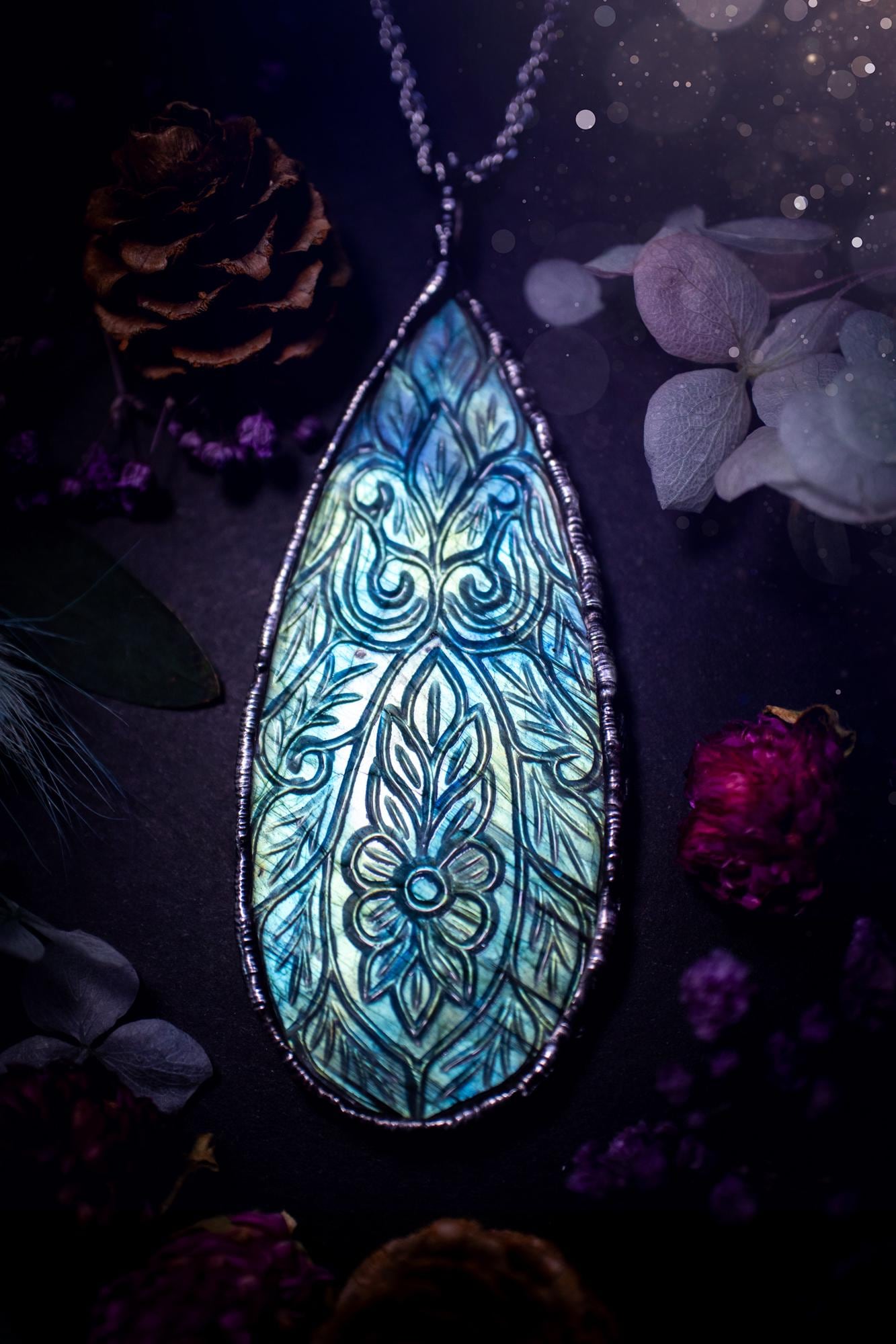 Beautifully handmade and bespoke, carved labradorite, soft soldered pendant necklace. This large labradorite pendant has been crafted using the soft solder method, also known as the tiffany technique. The crystal has a bezel of lead free soft solder which contains small parts of silver that allows for oxidisation and a high lustre polish. This labradorite is full of beautiful blues and greens and has been hand carved with a beautiful floral and leaf pattern. One off, gothic and witchy jewellery