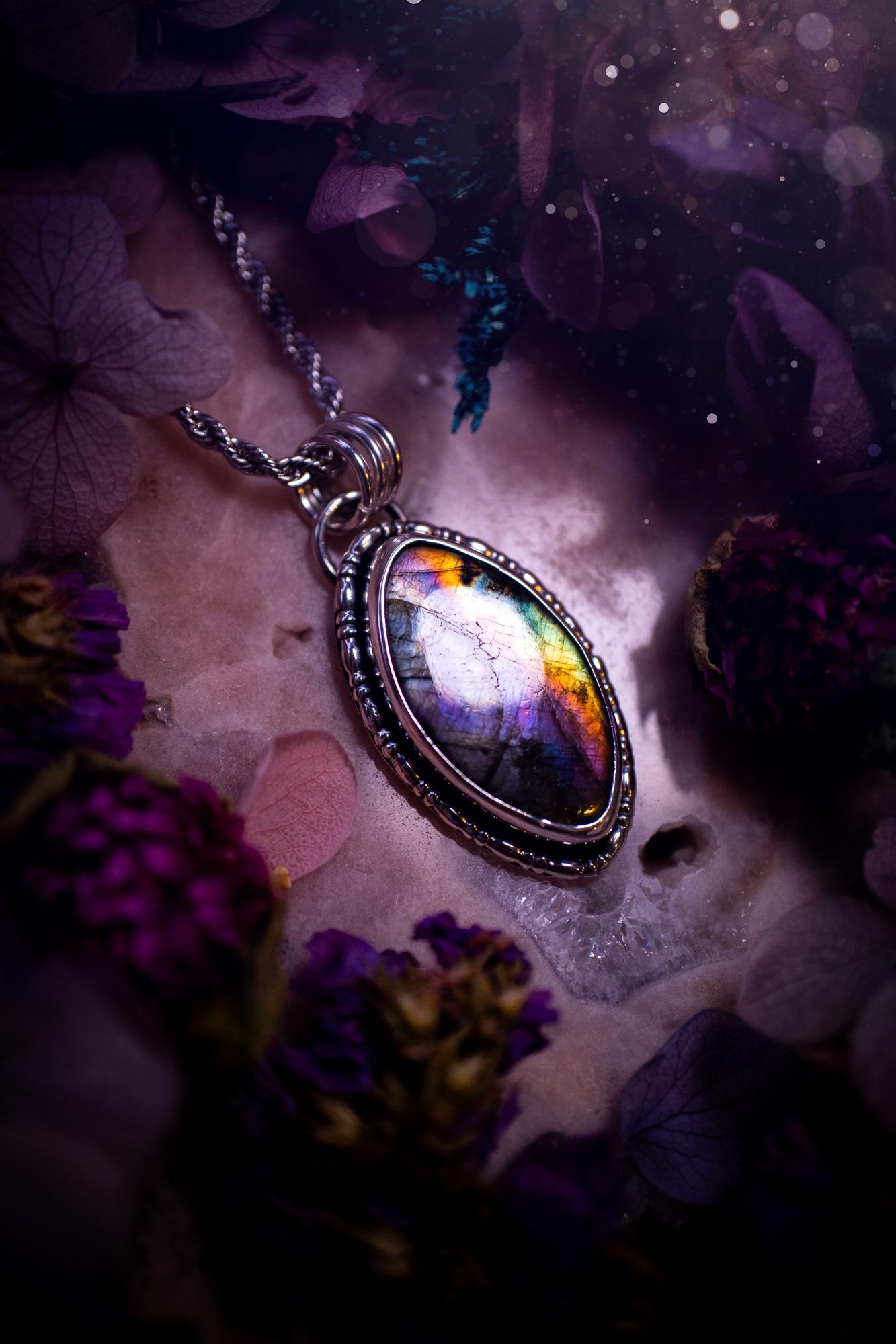 Beautifully handcrafted, rainbow labradorite crystal pendant necklace. This beautiful pendant has been crafted out of sterling and fine silver and features gothic bezel wire around the labradorite crystal. The labradorite in this piece is full of beautiful colours, purple, silvers, blues with a bit of orange! A really stunning crystal. This jewellery piece would be ideal for anyone who is a fan of jewellery and crystals, and would make the ideal gift. Full of witchy and gothic vibes!