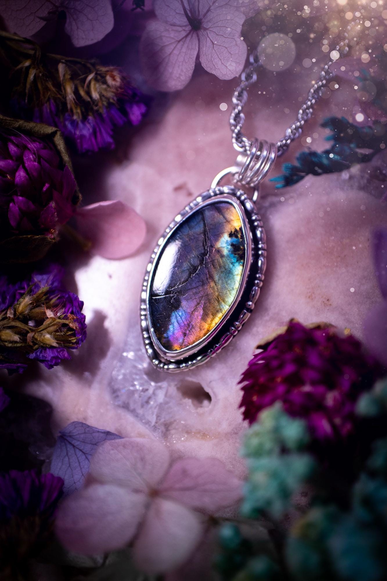 Beautifully handcrafted, rainbow labradorite crystal pendant necklace. This beautiful pendant has been crafted out of sterling and fine silver and features gothic bezel wire around the labradorite crystal. The labradorite in this piece is full of beautiful colours, purple, silvers, blues with a bit of orange! A really stunning crystal. This jewellery piece would be ideal for anyone who is a fan of jewellery and crystals, and would make the ideal gift. Full of witchy and gothic vibes!