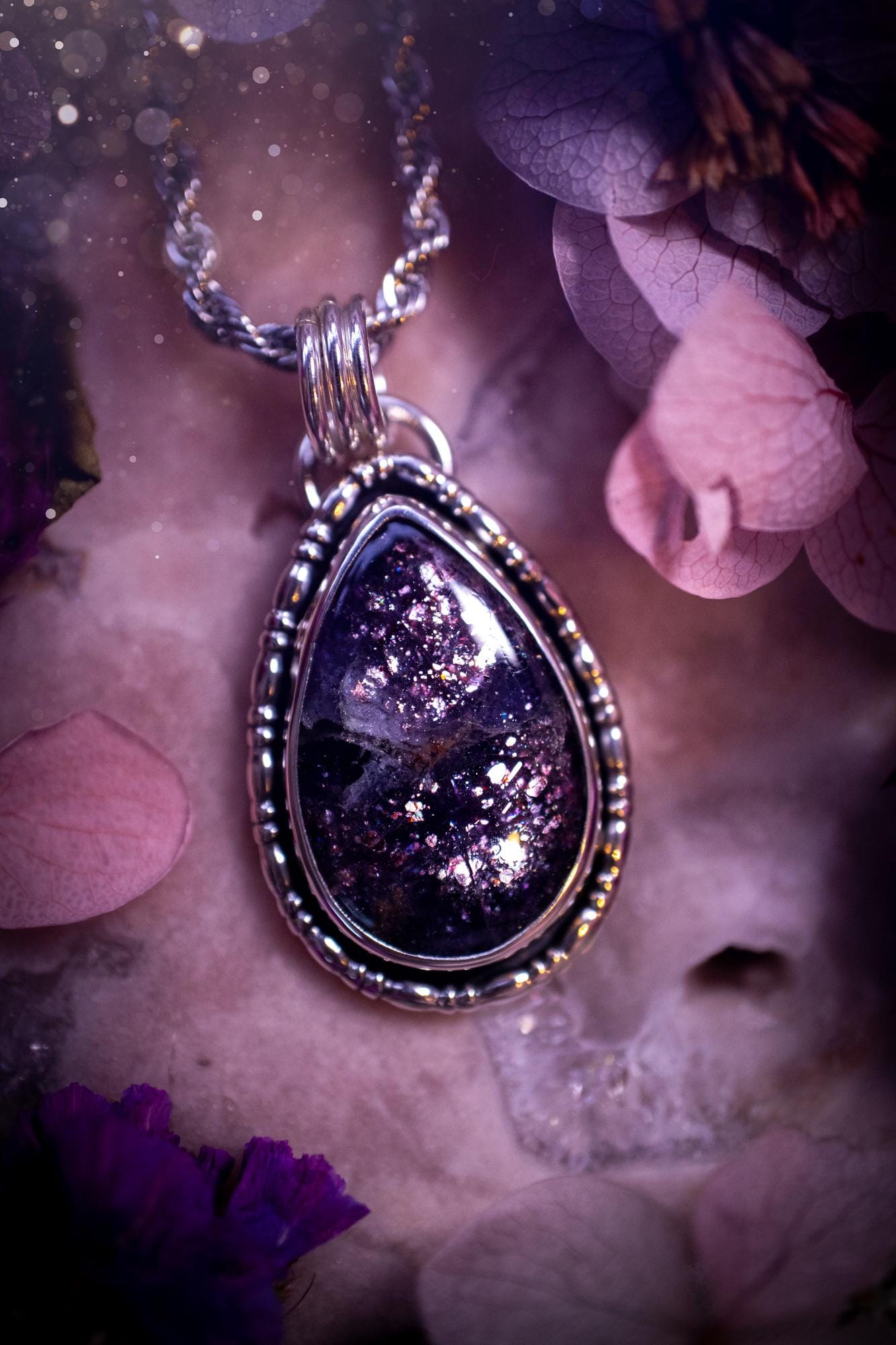 Stunning and handcrafted, natural Iolite sunstone, crystal pendant necklace. This beautiful pendant features a very sparkly iolite sunstone crystal that looks just like the galaxy, full of sparkle and pink shimmer. Made from a mix of sterling and fine silver, this piece is full of gothic vibes and has a gothic gallery wire around the crystal. Small and dainty. This piece would be suitable for gifting to jewellery and crystal lovers. Very witchy, gothic and hippy!