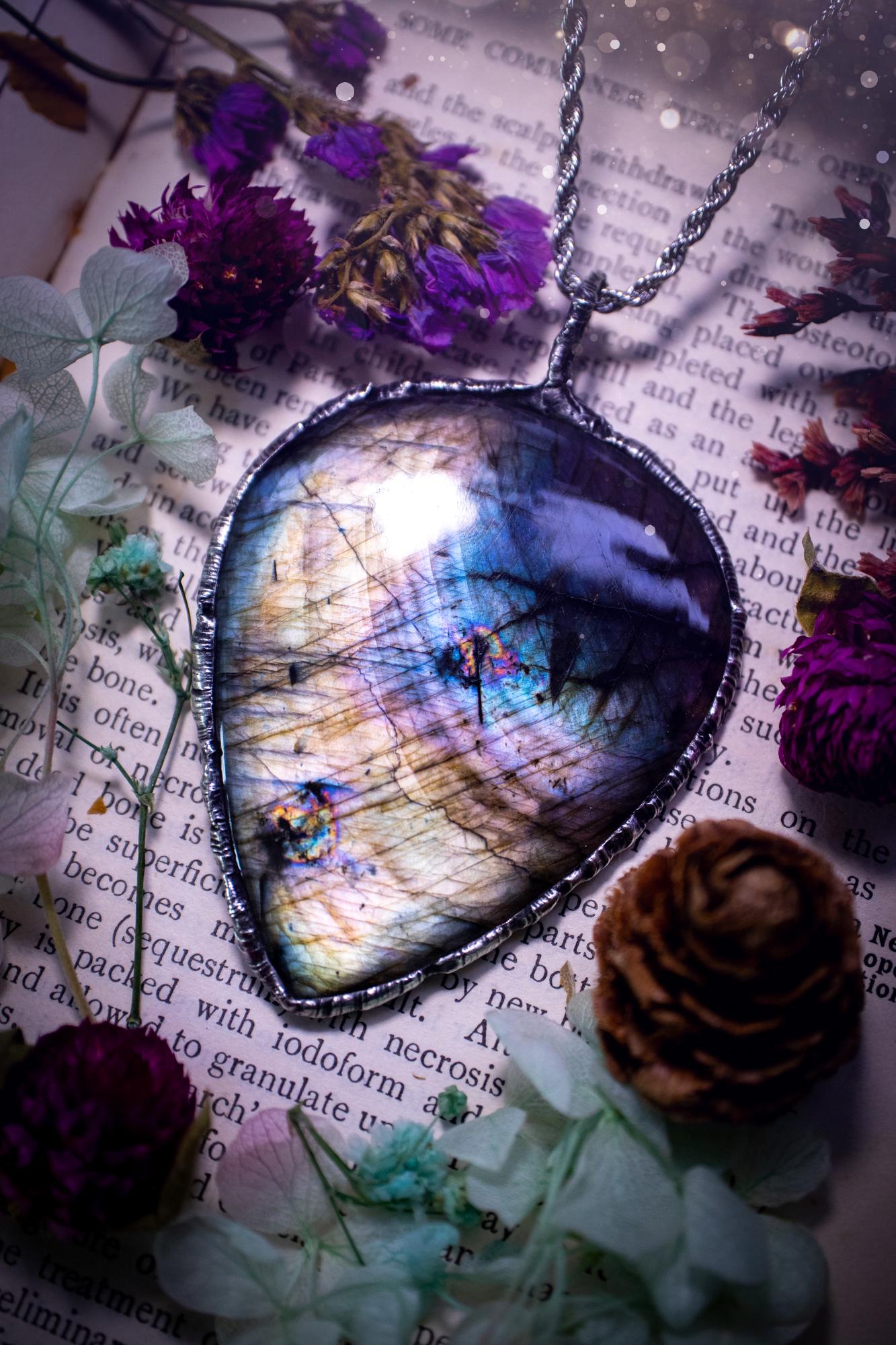 A very unique and one of a kind, soft soldered, labradorite, statement pendant necklace. The labradorite on this pendant is very unique as it is full of silver, purples and blues, with little rainbow clusters. It also has two separate flashing areas on the crystal. Large and beautiful! Handmade using the soft solder method also known as the tiffany technique! This piece of jewellery is a must have for any crystal and jewellery lover, it is full of gothic and witchy vibes! Jewellery for the soul