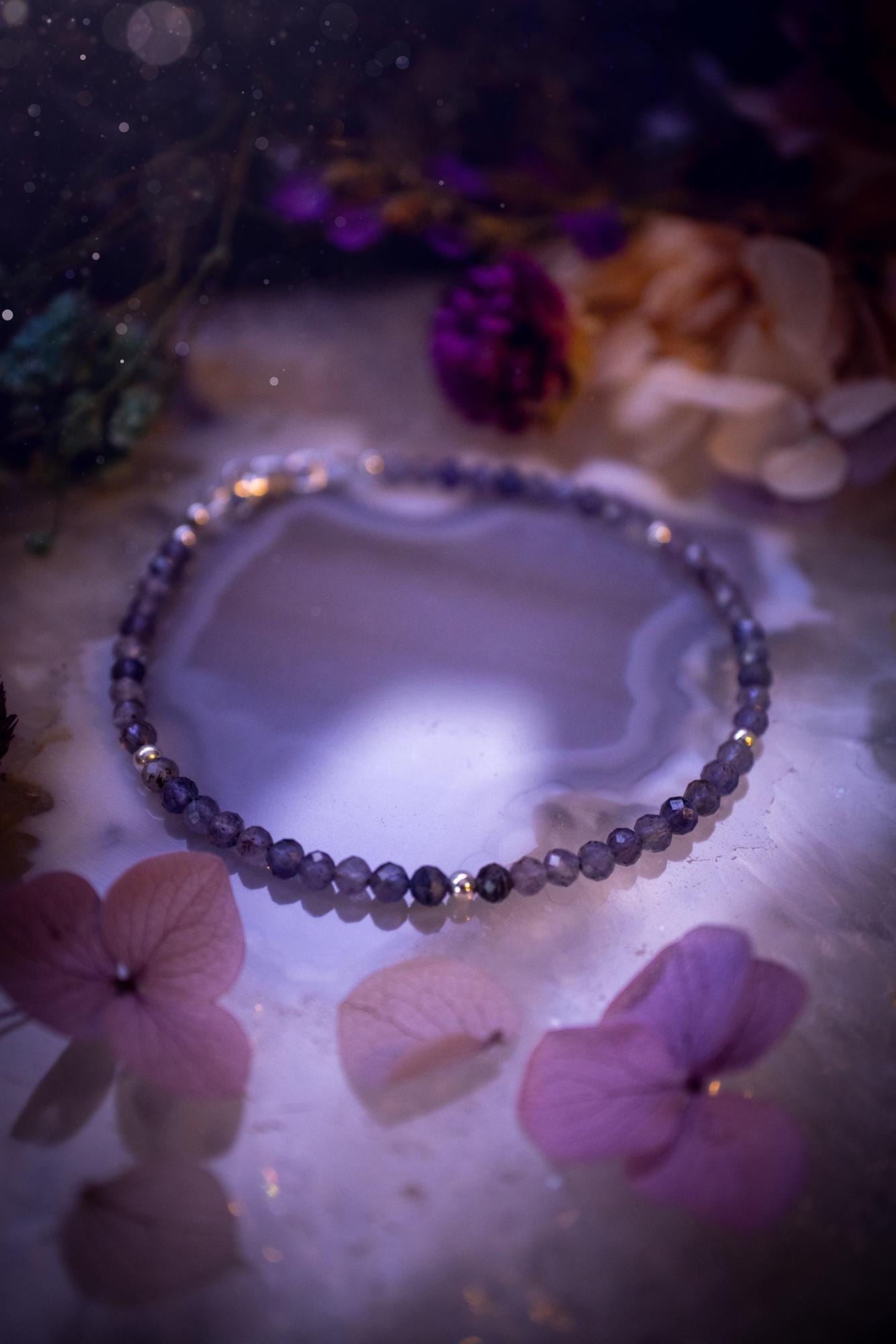 Beautifully handmade, and customisable, iolite crystal bead, stacking bracelet. This dainty crystal bracelet features high grade, genuine, rose cut, iolite crystal beads which give off a beautiful sparkle. They are a lovely purple and blue hue full of vibrancy. Strung on 49 strand beading wire with a choice of customisable findings to suit your style. Ideal for gifting, and suitable for any crystal and jewellery lover. Celestial, witchy and gothic.