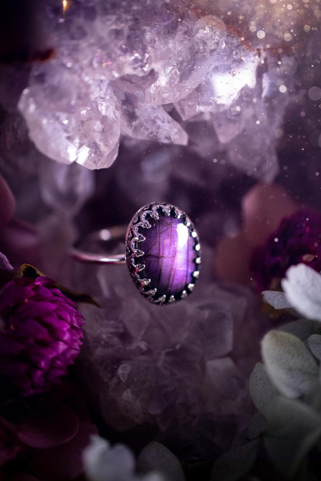 Handmade and very gothic, natural purple labradorite, sterling silver ring. This minimalist ring features a very pretty and flashy labradorite crystal that has a rich and vibrant purple colour. Around the crystal is a beautifully detail, gothic bezel that has been polished to a high lustre. The crystal is mounted on a 1.50mm ring shank. This ring would be ideal for anyone who loves jewellery and crystals, or who has a gothic and witchy style. A beautiful piece of jewellery to add to a collection