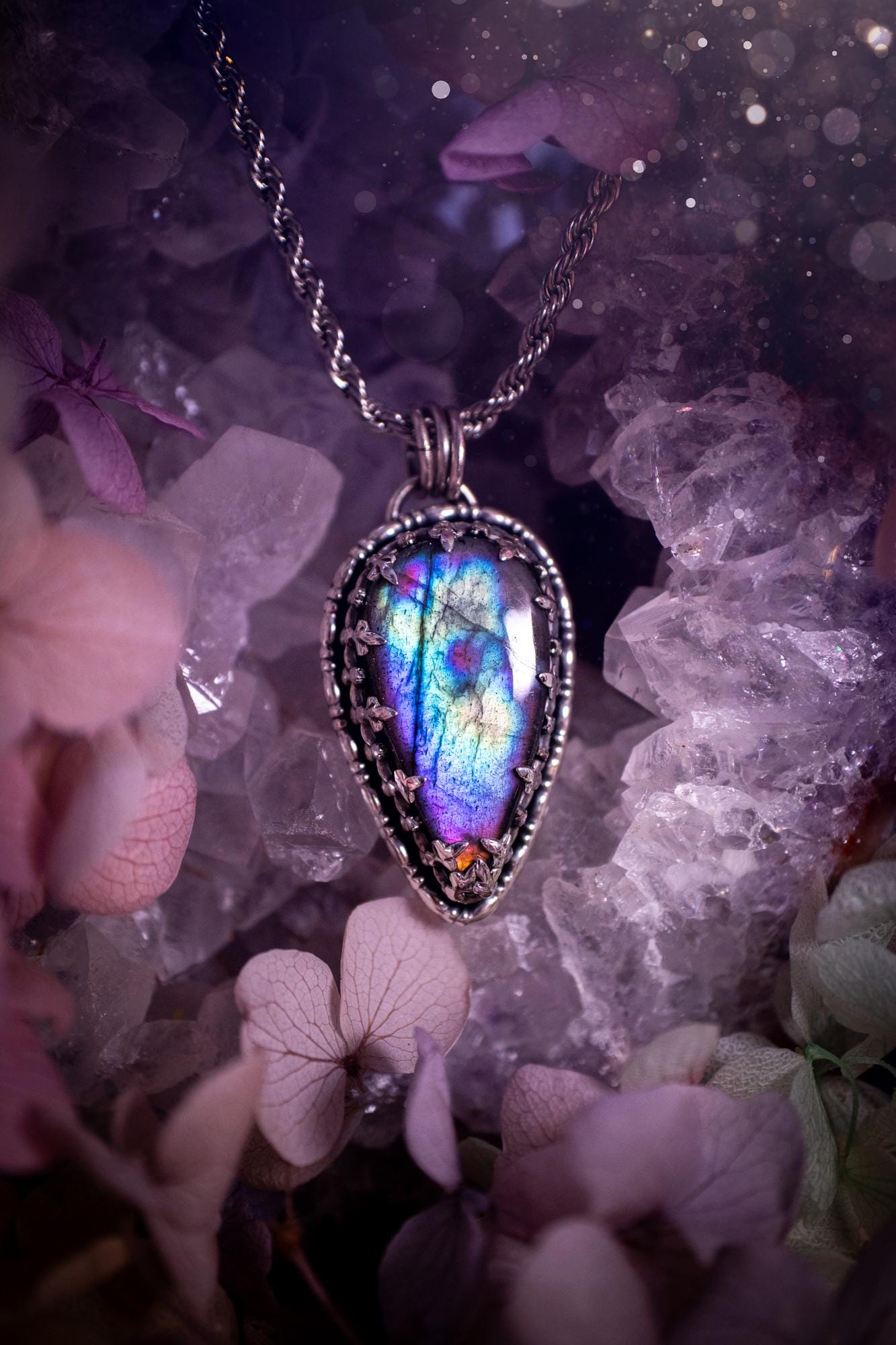Beautifully handcrafted, rainbow labradorite crystal pendant necklace. This beautiful pendant has been crafted out of sterling and fine silver and features a gothic bezel around the labradorite crystal. The labradorite in this piece is full of beautiful colours, purple, greens, blues with a bit of orange! A really stunning crystal. This jewellery piece would be ideal for anyone who is a fan of jewellery and crystals, and would make the ideal gift. Full of witchy and gothic vibes!