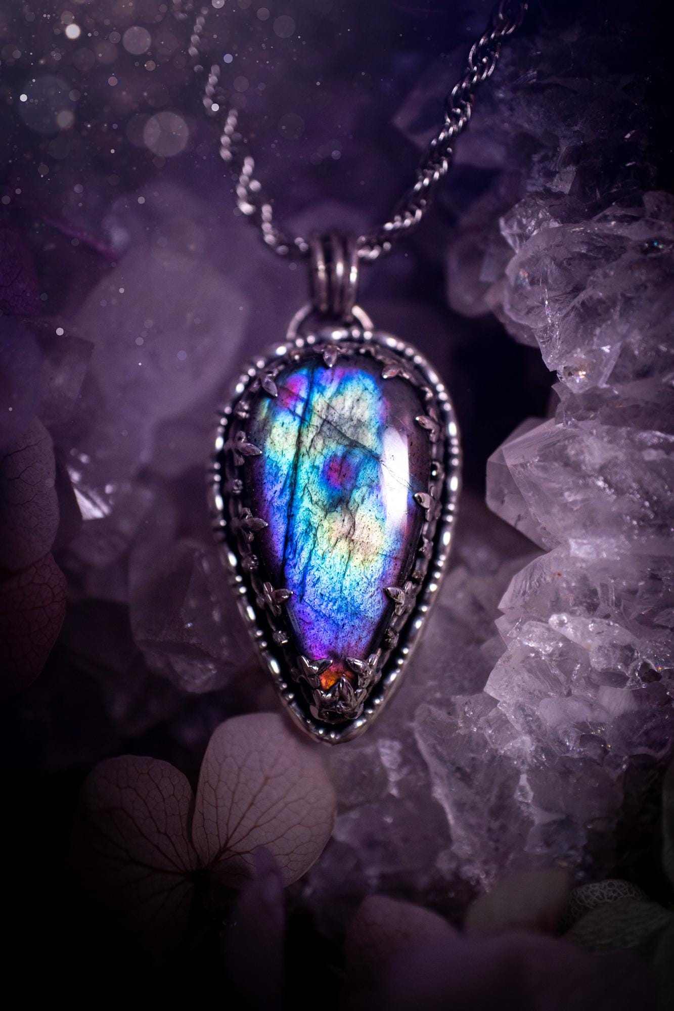 Beautifully handcrafted, rainbow labradorite crystal pendant necklace. This beautiful pendant has been crafted out of sterling and fine silver and features a gothic bezel around the labradorite crystal. The labradorite in this piece is full of beautiful colours, purple, greens, blues with a bit of orange! A really stunning crystal. This jewellery piece would be ideal for anyone who is a fan of jewellery and crystals, and would make the ideal gift. Full of witchy and gothic vibes!