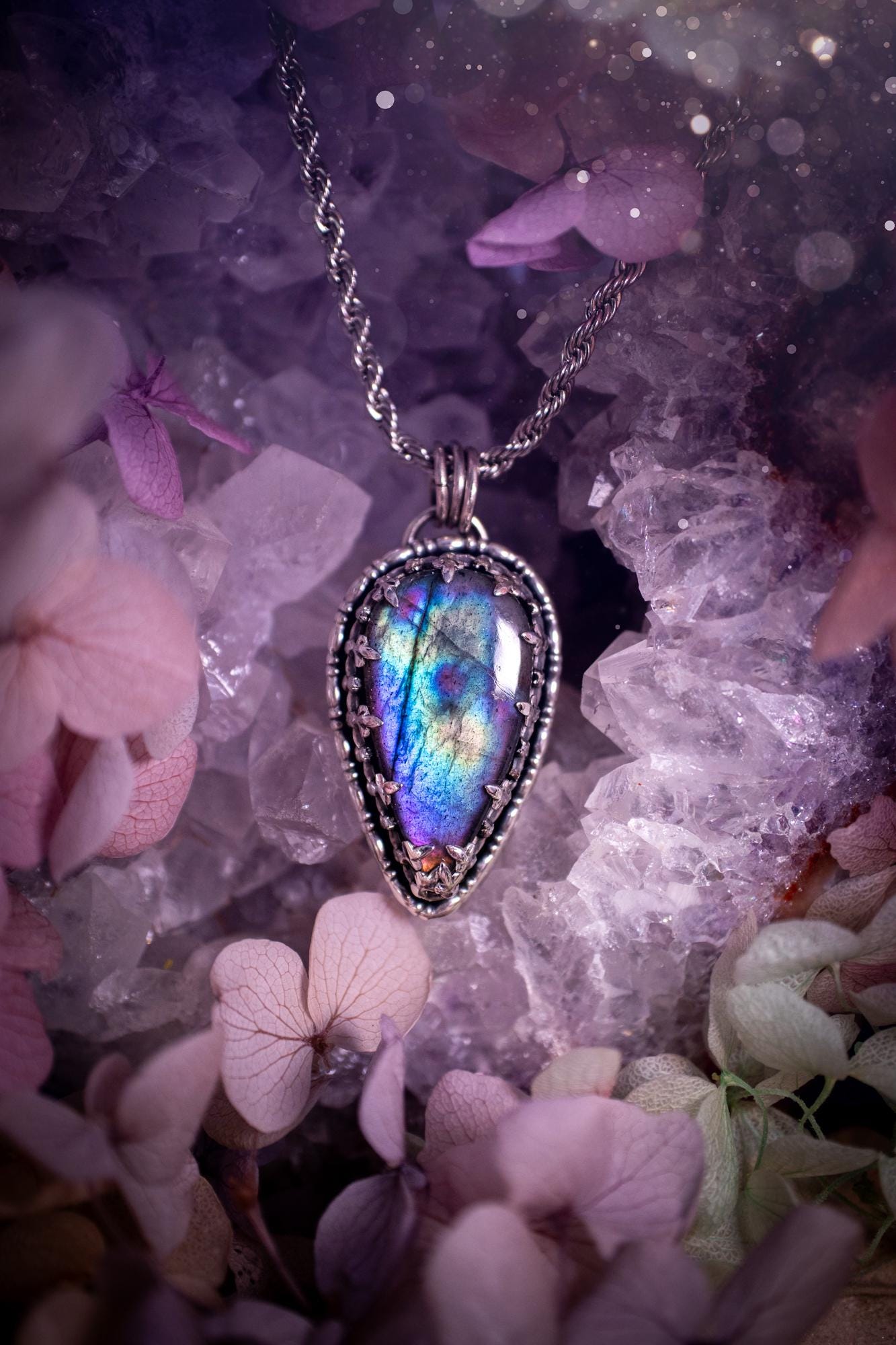 Beautifully handcrafted, rainbow labradorite crystal pendant necklace. This beautiful pendant has been crafted out of sterling and fine silver and features a gothic bezel around the labradorite crystal. The labradorite in this piece is full of beautiful colours, purple, greens, blues with a bit of orange! A really stunning crystal. This jewellery piece would be ideal for anyone who is a fan of jewellery and crystals, and would make the ideal gift. Full of witchy and gothic vibes!