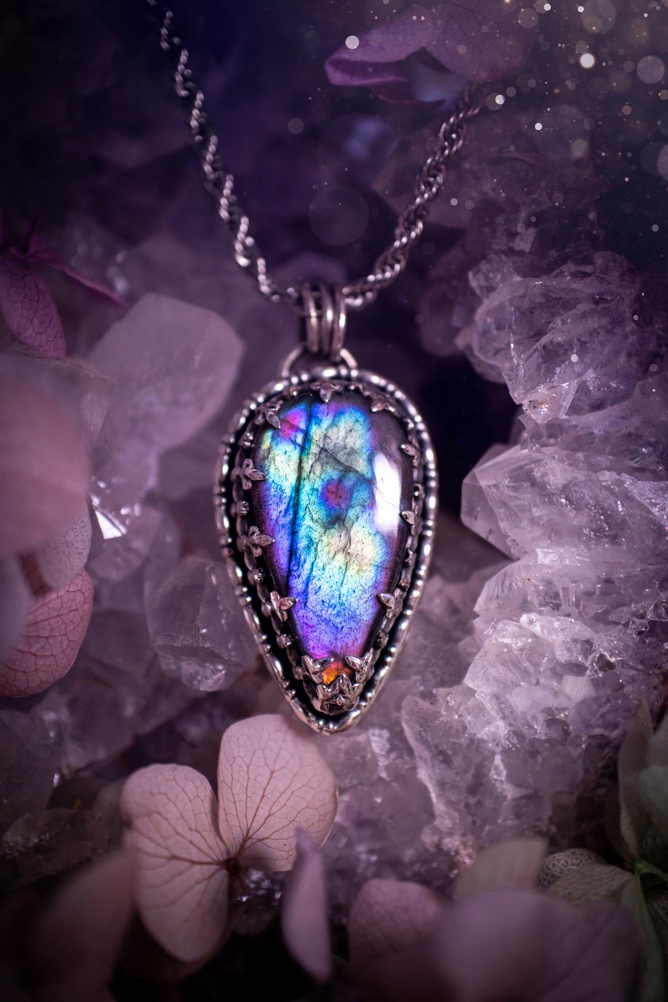 Beautifully handcrafted, rainbow labradorite crystal pendant necklace. This beautiful pendant has been crafted out of sterling and fine silver and features a gothic bezel around the labradorite crystal. The labradorite in this piece is full of beautiful colours, purple, greens, blues with a bit of orange! A really stunning crystal. This jewellery piece would be ideal for anyone who is a fan of jewellery and crystals, and would make the ideal gift. Full of witchy and gothic vibes!