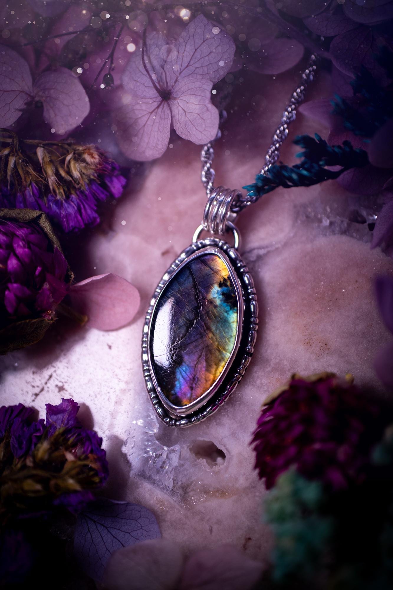 Beautifully handcrafted, rainbow labradorite crystal pendant necklace. This beautiful pendant has been crafted out of sterling and fine silver and features gothic bezel wire around the labradorite crystal. The labradorite in this piece is full of beautiful colours, purple, silvers, blues with a bit of orange! A really stunning crystal. This jewellery piece would be ideal for anyone who is a fan of jewellery and crystals, and would make the ideal gift. Full of witchy and gothic vibes!