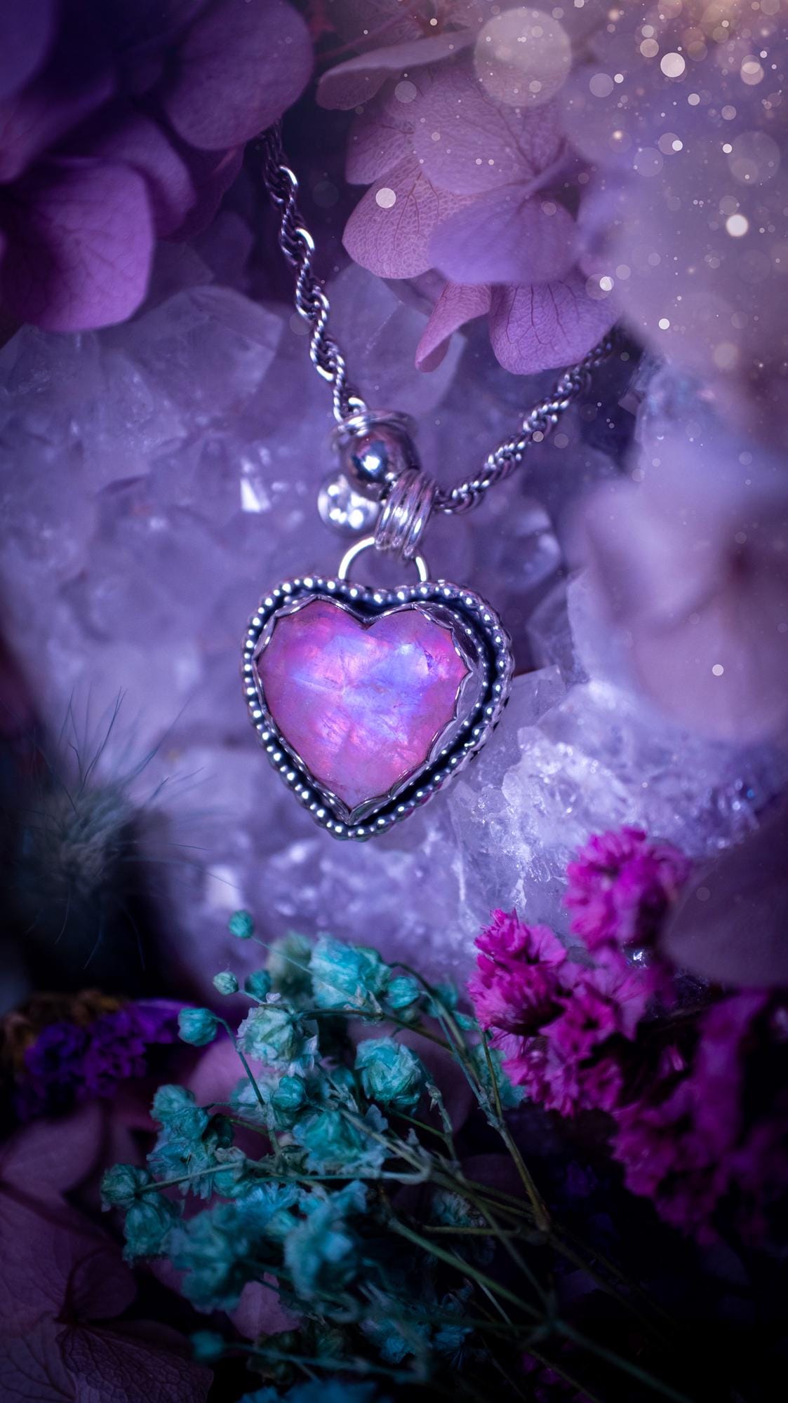 Handmade and bespoke, pink rainbow moonstone heart, sterling silver pendant necklace. This lovely pendant feature a very high quality rainbow moonstone that is full of gorgeous pink and blue flash. This unusual pink colour has been created by using materials under the stone so the pink hue shines through with the iridescence of the moonstone. Made from fine and sterling silver. An ideal piece for any crystal and jewellery lover. Moonstone is the birthstone for June. Unique gothic jewellery