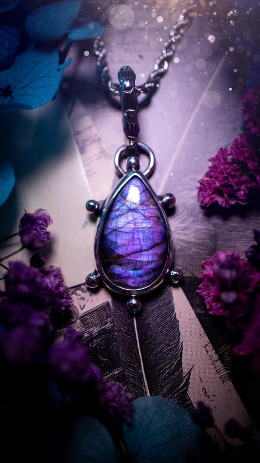 One of a kind and very unique, purple and pink labradorite, crystal pendant necklace. This bohemian style pendant necklace has been handcrafted using a mix of fine and sterling silver. Featuring a purple coloured labradorite that has such a strong intense flash full of beautiful hue. Around the smooth bezel is small silver ball details, and a bohemian stamped pattern bail. This pendant necklace would be ideal for anyone who loves crystal and jewellery. One of pieces of jewellery for the soul.