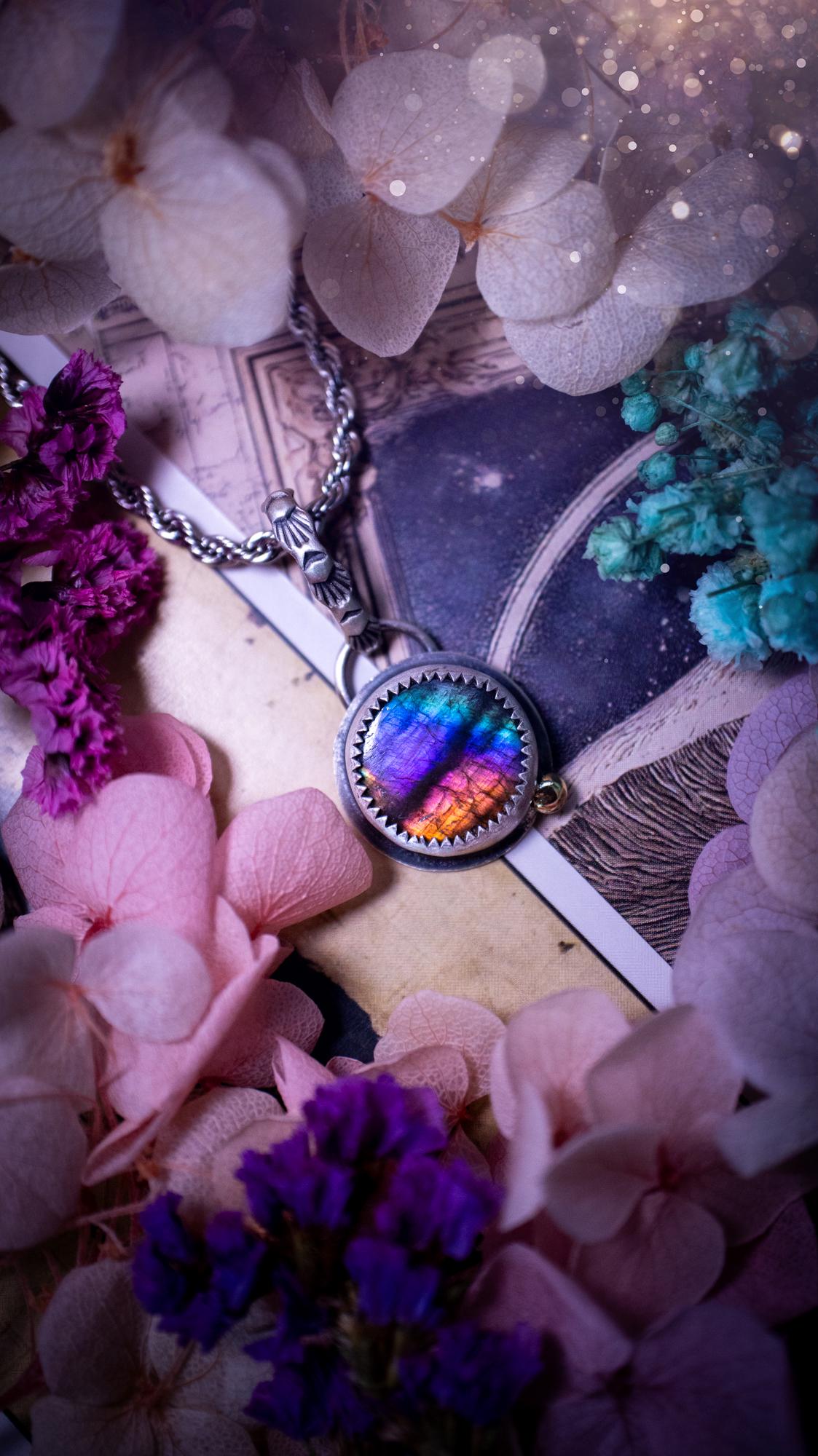 Handmade rainbow labradorite pendant set in sterling silver with a satin brushed finish. The natural labradorite gemstone shows flashes of blue, gold and rainbow tones depending on the light. Features a polished brass golden ball accent and a decorative patterned bail. Bohemian, gothic and witchy style crystal jewellery, perfect as a unique gift or everyday statement piece.
