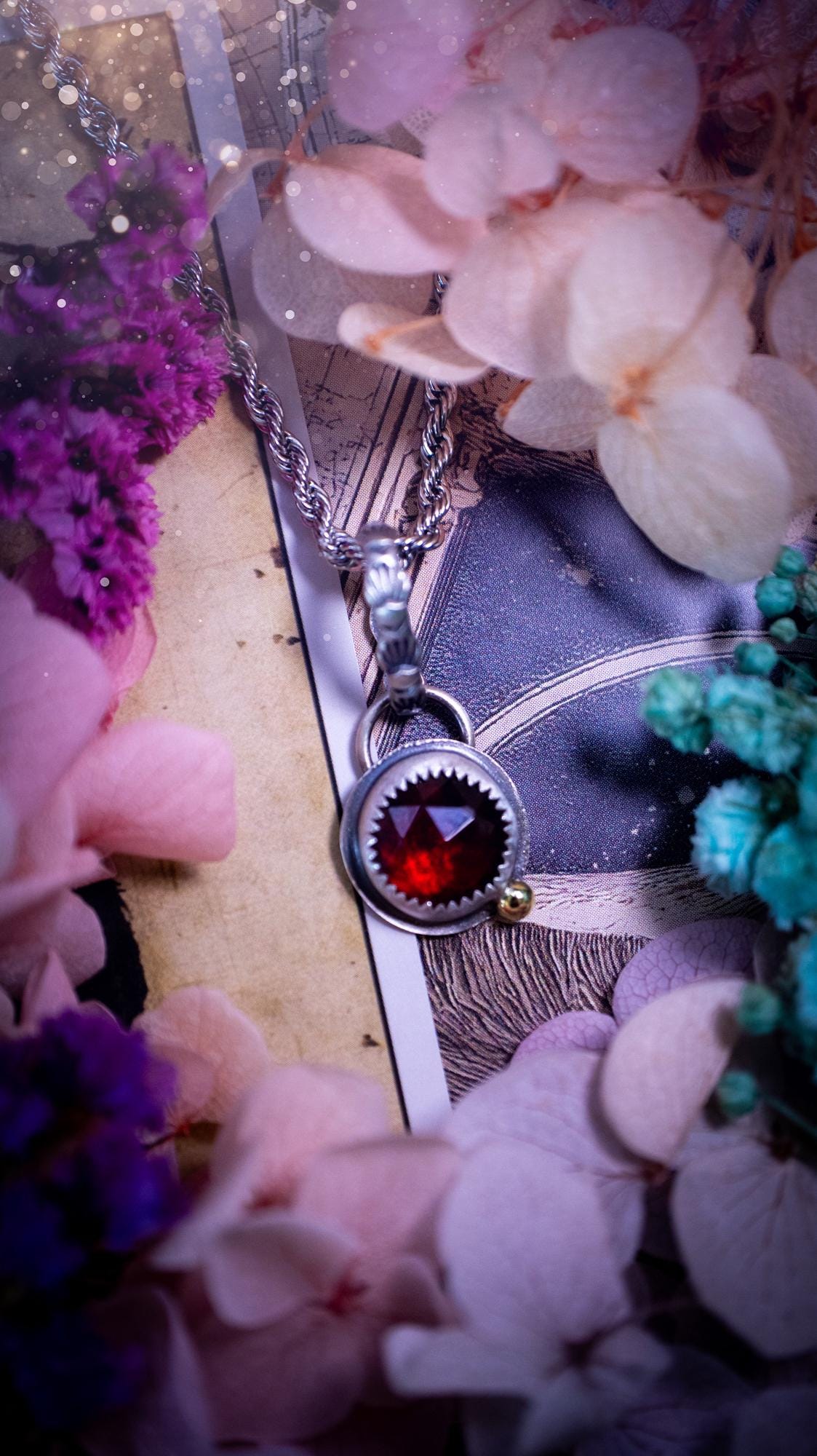 Handmade garnet pendant set in sterling silver with a satin brushed finish. The deep red natural garnet gemstone has a rich, wine-toned colour that catches the light beautifully. Finished with a polished brass golden ball accent and a decorative patterned bail. Gothic, bohemian and witchy style crystal jewellery, perfect as a meaningful gift or elegant everyday statement piece.