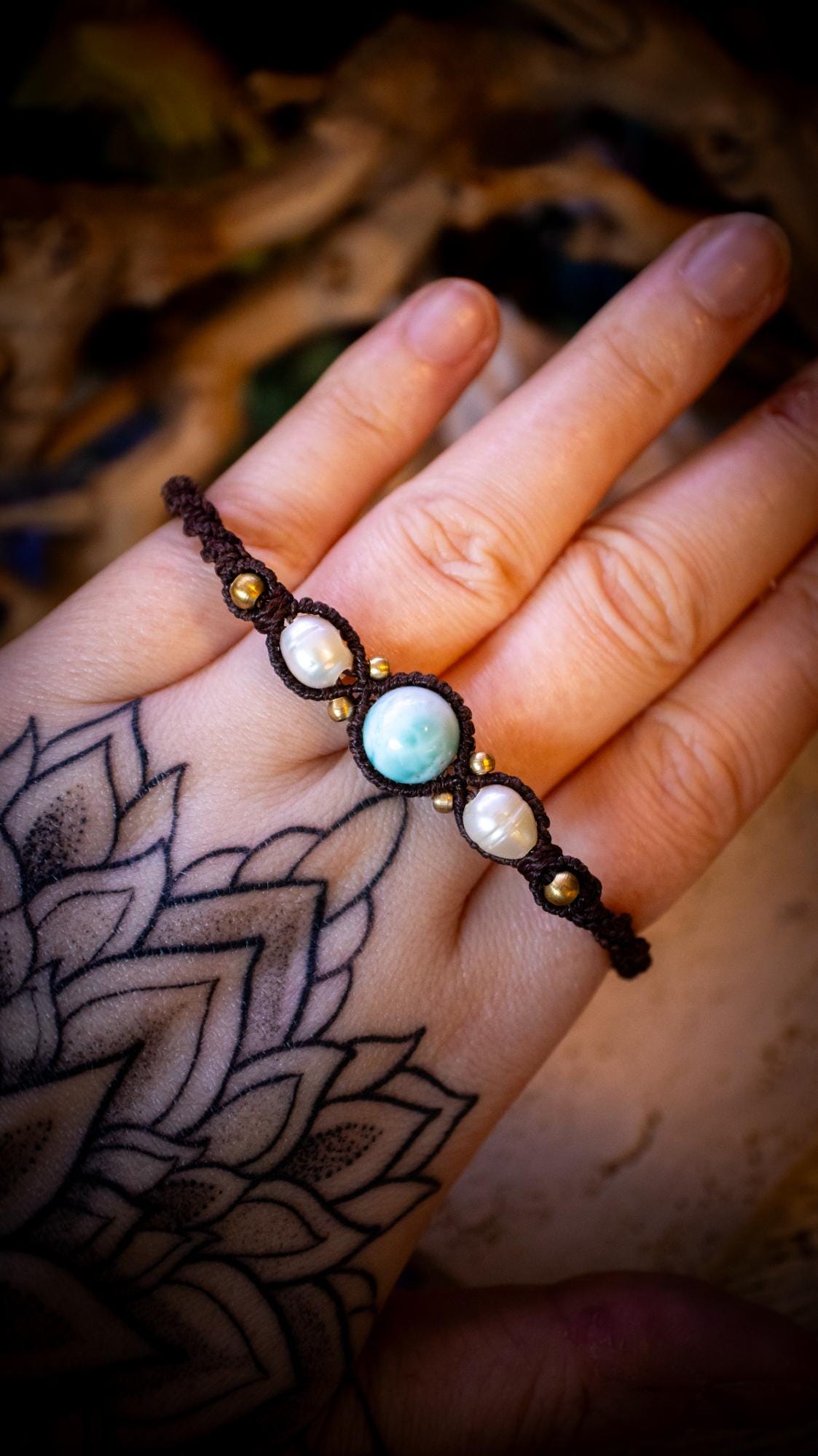 Beautiful and handmade, larimar with fresh water pearls macrame bracelet. This bracelet has been handmade using high quality Linhasita wax cord which is a dark brown colour. Featuring stunning, high quality Larimar crystal beads that are full of natural pattern. There are brass beads within the macrame pattern and fresh water pearls. A lovely little gift for a close one, or a little treat for yourself! Ideal for birthdays, anniversaries, and special occasions. Hippy jewellery for the soul.