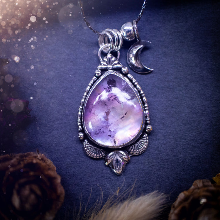 Beautiful and handcrafted, sterling silver amethyst and mother of pearl pendant necklace. Full of iridescent shine with a gorgeous purple hue. Complete with silver components and a little moon charm.