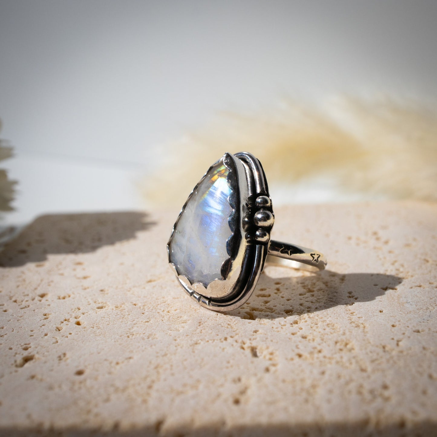 Beautiful Rainbow Moonstone ring set in fine and sterling silver. Featuring a scallop bezel, stars on the ring shank and silver accents. Size P