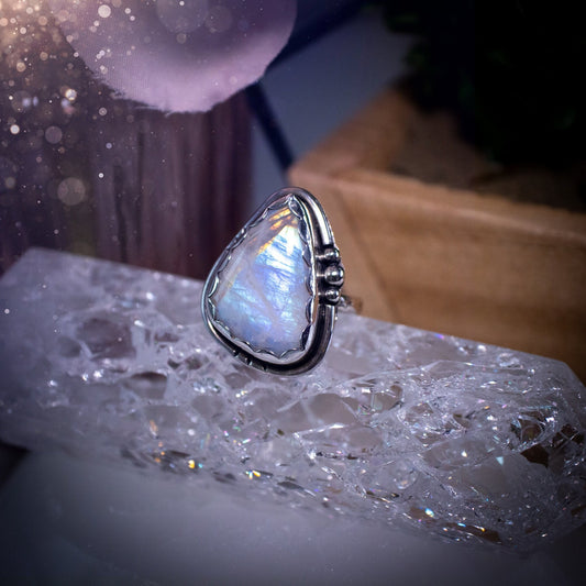 Beautiful Rainbow Moonstone ring set in fine and sterling silver. Featuring a scallop bezel, stars on the ring shank and silver accents. Size P