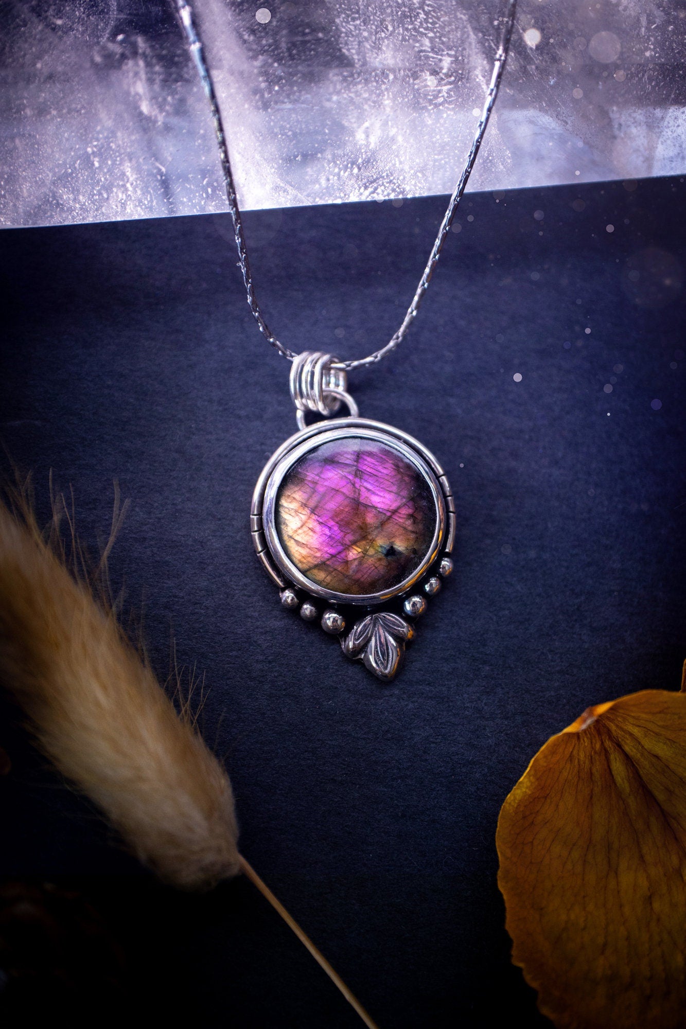 Beautiful and handmade, natural pink, purple and orange labradorite, crystal pendant necklace. This necklace has been made from fine and sterling silver and features silver leaf and ball components. The ideal gift for crystal lovers. Hippy, gothic.