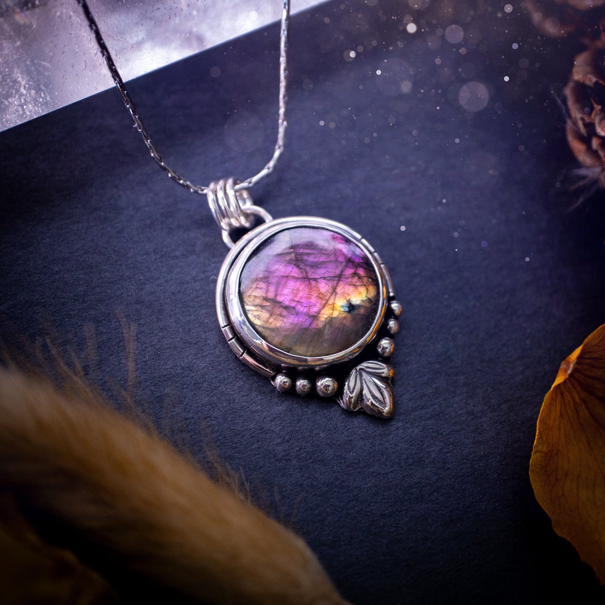 Beautiful and handmade, natural pink, purple and orange labradorite, crystal pendant necklace. This necklace has been made from fine and sterling silver and features silver leaf and ball components. The ideal gift for crystal lovers. Hippy, gothic.