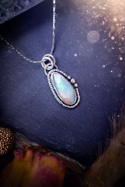 Flashy, natural, rose cut Ethiopian Welo Opal pendant necklace. This beautiful piece of jewellery is hand made, and has been created out of sterling silver. Accompanying this crystal is silver ball and wire components, making an ideal gift for hippys