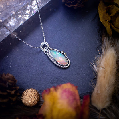 Flashy, natural, rose cut Ethiopian Welo Opal pendant necklace. This beautiful piece of jewellery is hand made, and has been created out of sterling silver. Accompanying this crystal is silver ball and wire components, making an ideal gift for hippys