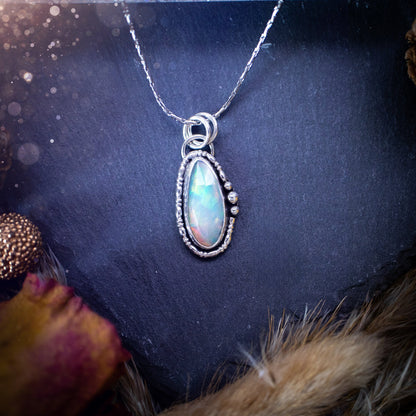 Flashy, natural, rose cut Ethiopian Welo Opal pendant necklace. This beautiful piece of jewellery is hand made, and has been created out of sterling silver. Accompanying this crystal is silver ball and wire components, making an ideal gift for hippys