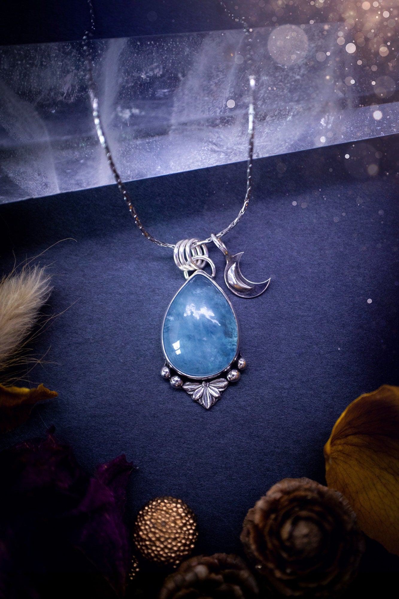 Bold and beautiful, blue aquamarine crystal pendant necklace. This pendant has been handcrafted out of fine and sterling silver. The piece also has a little moon charm. Suitable for jewellery gifts. Gothic, hippy and ideal for her. March birthstone