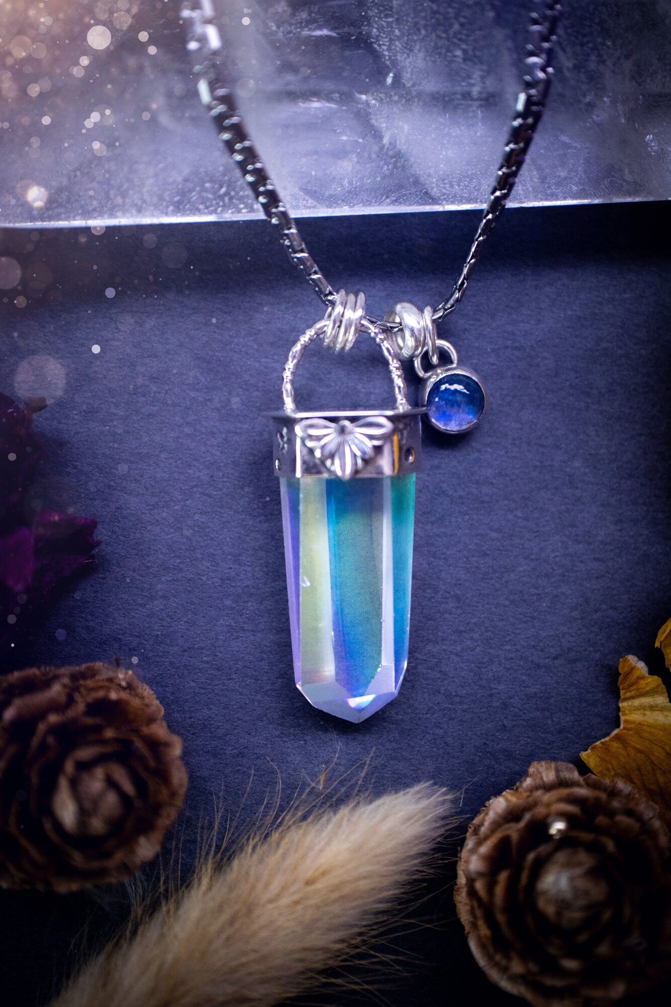 Beautiful, handmade aura quartz crystal point pendant necklace with rainbow moonstone charm. This pendant is a statement and has been handcrafted out of recycled fine and sterling silver. Featuring star stamp detail. Ideal for crystal lovers, gothic