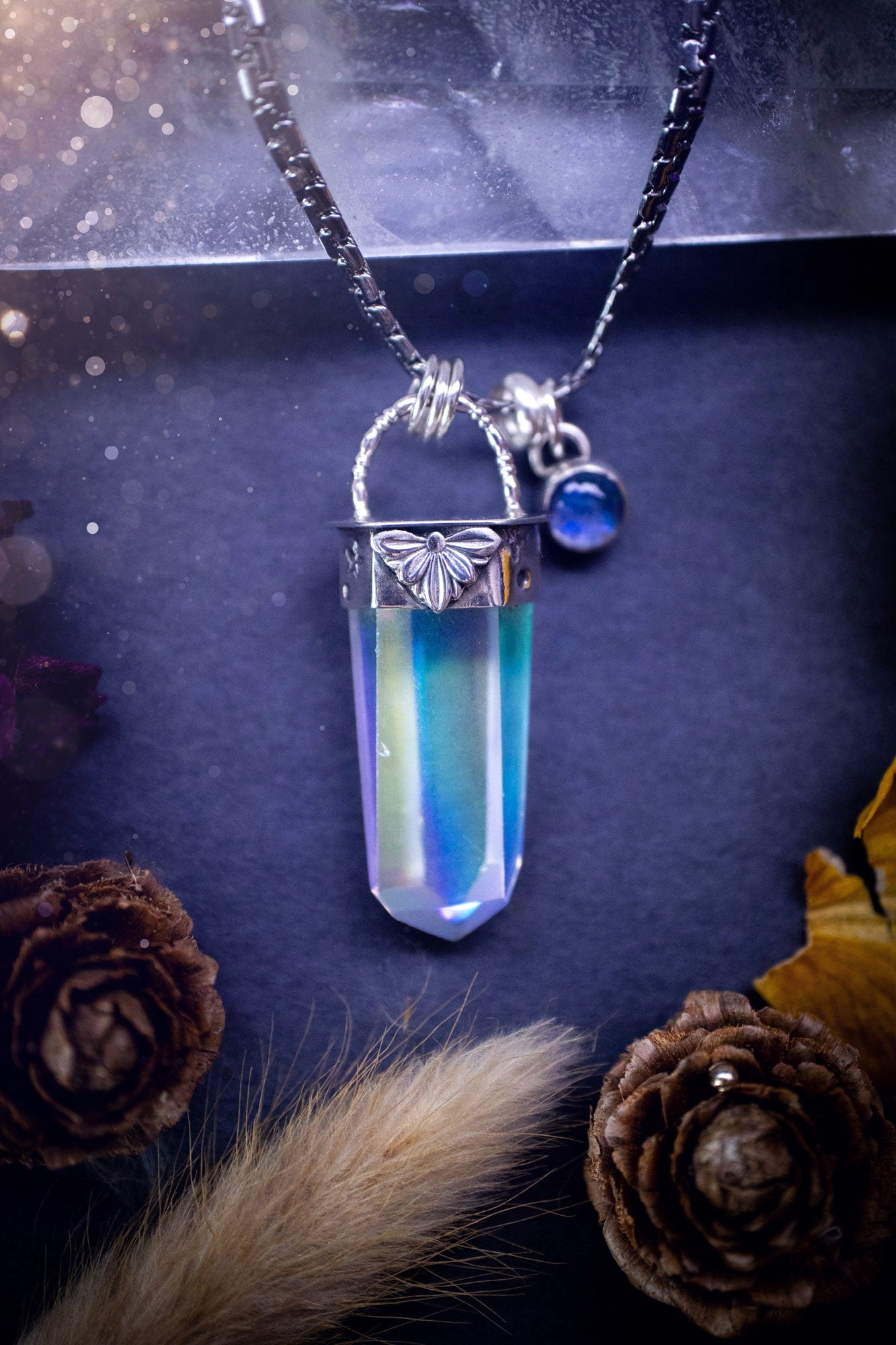 Beautiful, handmade aura quartz crystal point pendant necklace with rainbow moonstone charm. This pendant is a statement and has been handcrafted out of recycled fine and sterling silver. Featuring star stamp detail. Ideal for crystal lovers, gothic