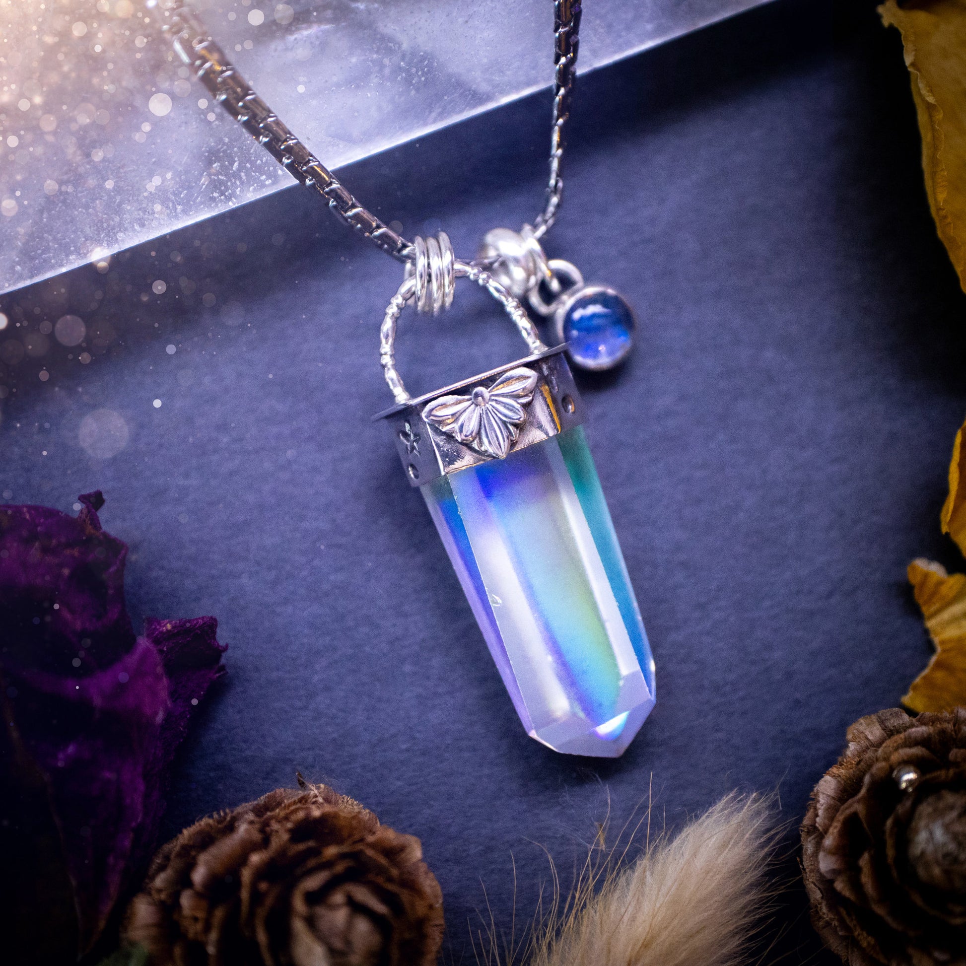 Beautiful, handmade aura quartz crystal point pendant necklace with rainbow moonstone charm. This pendant is a statement and has been handcrafted out of recycled fine and sterling silver. Featuring star stamp detail. Ideal for crystal lovers, gothic