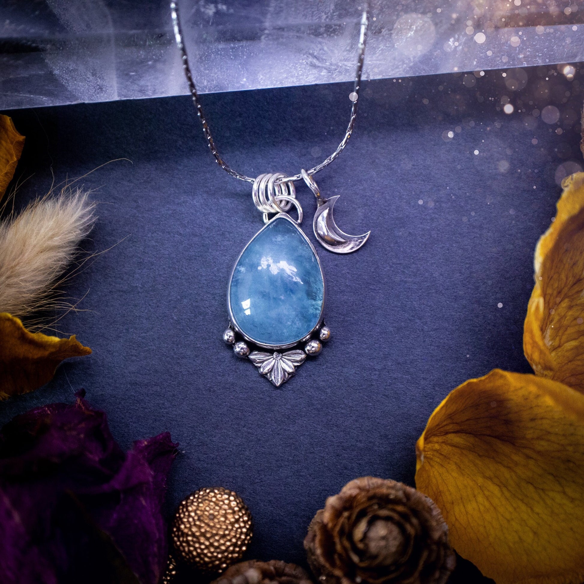 Bold and beautiful, blue aquamarine crystal pendant necklace. This pendant has been handcrafted out of fine and sterling silver. The piece also has a little moon charm. Suitable for jewellery gifts. Gothic, hippy and ideal for her. March birthstone