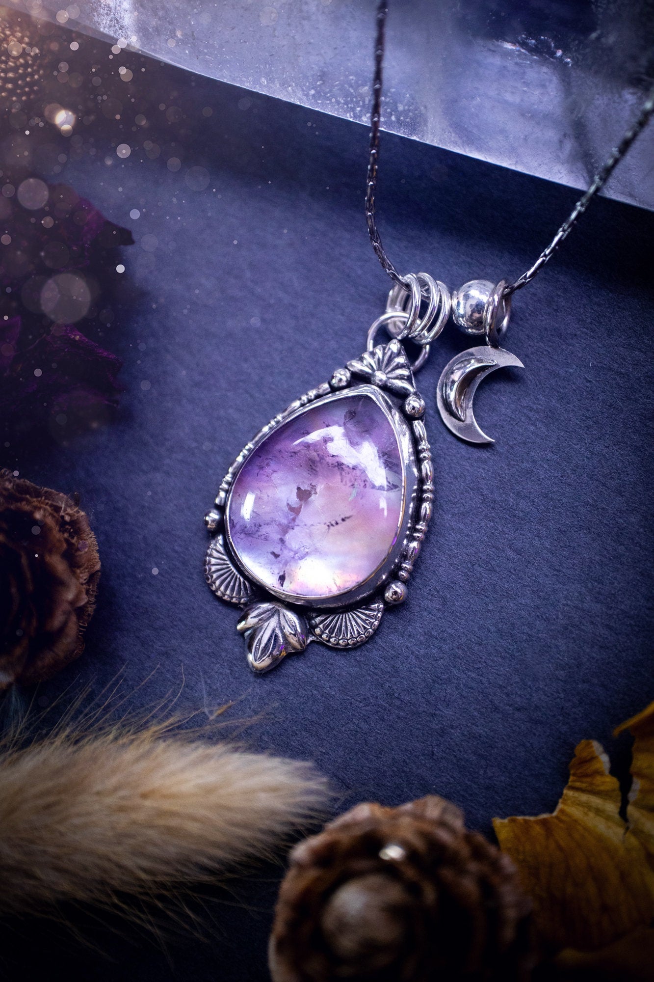 Beautiful, handmade aura quartz crystal point pendant necklace with rainbow moonstone charm. This pendant is a statement and has been handcrafted out of recycled fine and sterling silver. Featuring star stamp detail. Ideal for crystal lovers, gothic