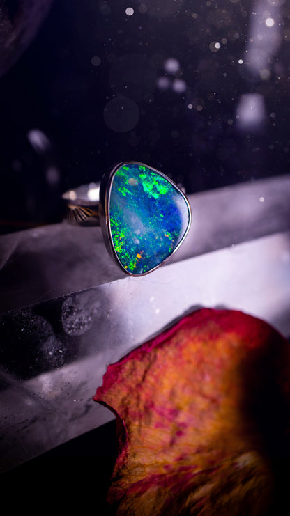 Beautiful and flashy, Australian Opal Doublet ring. Set in sterling and fine silver, this ring will make the ideal gift for that special person. Full of reds, greens, and blues in the natural crystal opal, with stamped ring shank. Size O 1/2