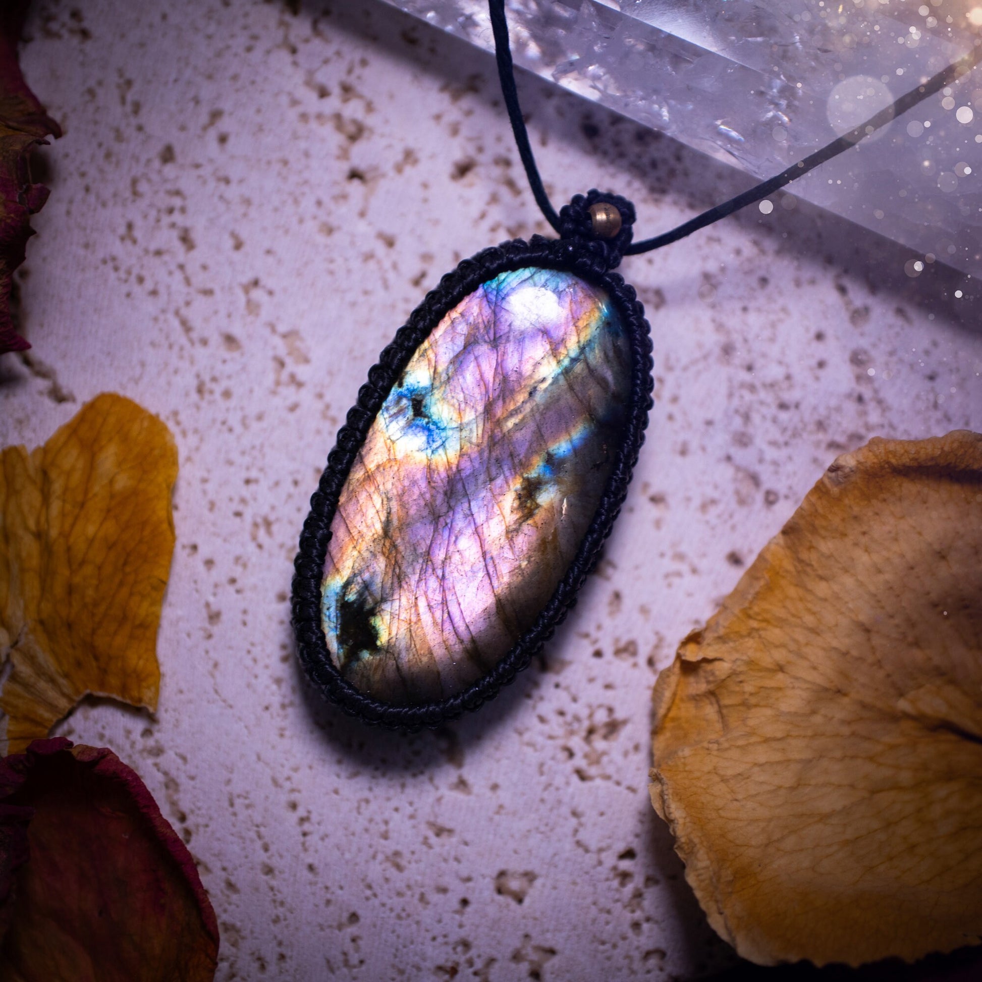 Handcrafted, purple and pink, labradorite spectrolite pendant necklace. This piece of jewellery features a fairy tale crystal full of magical colours. Has been handmade using high quality Linhasita cord. Ideal gift for hippies and crystal lovers.