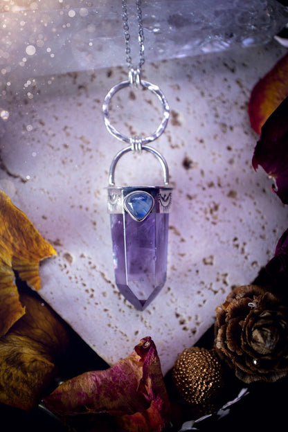 Beautifully handcrafted smoky phantom amethyst pointed pendant necklace. Featuring a small and flashy rainbow moonstone on the bezel which has been made from recycled sterling silver. Gorgeous inclusions in the amethyst. Ideal crystal gifts for her.