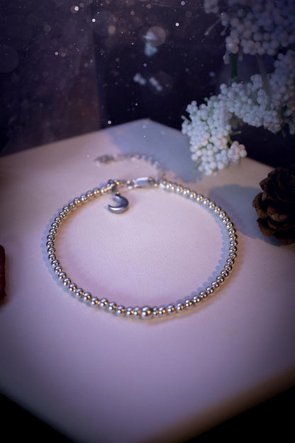 Beautiful and handmade, 3mm beaded, sterling silver stacking bracelet. This bracelet has been made using high quality sterling silver beads which have bee strung on strong 49 strand beading wire. This wire is very strong, but also gives a beautiful drape across the wrist. Featuring one larger silver spacer bead in the middle with rondelle beads either side to give some uniqueness. This bracelet is ideal for stacking with others, and makes a lovely gift for jewellery lovers.