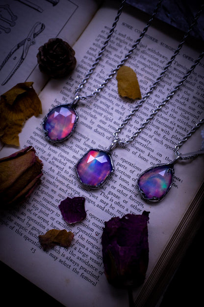 A beautiful, one of a kind, aurora opal pendant necklace. This little statement necklace is handmade using the tiffany technique, also known as soft soldering. Featuring the most stunning, and sparkly aurora opal which is full of pinks, greens and blues just like the northern lights. Aurora opals are man made opals that look similar to natural ones, they have a layer of rose quartz on top to give extra shine. The ideal gift for any crystal or jewellery lover. Gothic and witchy jewellery