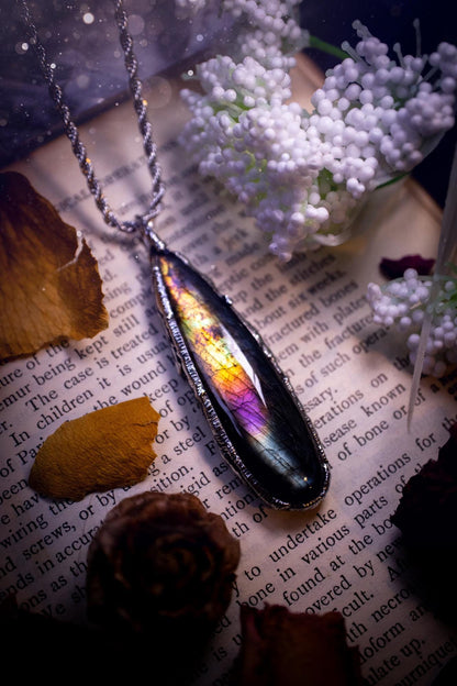 A beautiful, one of a kind, purple, green and grey multi-flash Labradorite crystal pendant necklace. This pendant has been handmade using the soft solder method, also known as the tiffany technique used to create stained glass windows. Featuring the most stunning and natural Labradorite crystal which is full of purple and green hues. The  pendant is suitable for gifting to any jewellery or crystal lover, or to simply add to your own collection. One of a kind jewellery, gothic and witchy gifts