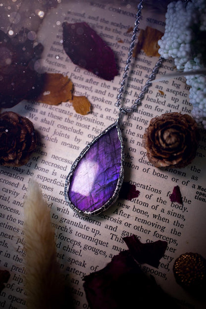 A beautiful, one of a kind, purple, green and grey multi-flash Labradorite crystal pendant necklace. This pendant has been handmade using the soft solder method, also known as the tiffany technique used to create stained glass windows. Featuring the most stunning and natural Labradorite crystal which is full of purple and green hues. The  pendant is suitable for gifting to any jewellery or crystal lover, or to simply add to your own collection. One of a kind jewellery, gothic and witchy gifts