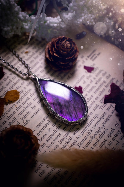A beautiful, one of a kind, purple, green and grey multi-flash Labradorite crystal pendant necklace. This pendant has been handmade using the soft solder method, also known as the tiffany technique used to create stained glass windows. Featuring the most stunning and natural Labradorite crystal which is full of purple and green hues. The  pendant is suitable for gifting to any jewellery or crystal lover, or to simply add to your own collection. One of a kind jewellery, gothic and witchy gifts