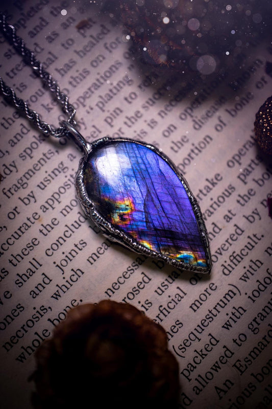 A beautiful, one of a kind, purple, green and grey multi-flash Labradorite crystal pendant necklace. This pendant has been handmade using the soft solder method, also known as the tiffany technique used to create stained glass windows. Featuring the most stunning and natural Labradorite crystal which is full of purple and green hues. The  pendant is suitable for gifting to any jewellery or crystal lover, or to simply add to your own collection. One of a kind jewellery, gothic and witchy gifts