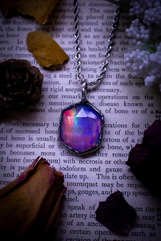 A beautiful, one of a kind, aurora opal pendant necklace. This little statement necklace is handmade using the tiffany technique, also known as soft soldering. Featuring the most stunning, and sparkly aurora opal which is full of pinks, greens and blues just like the northern lights. Aurora opals are man made opals that look similar to natural ones, they have a layer of rose quartz on top to give extra shine. The ideal gift for any crystal or jewellery lover. Gothic and witchy jewellery