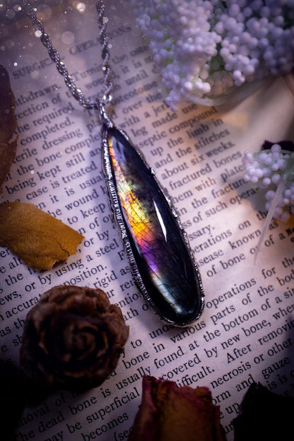 A beautiful, one of a kind, purple, green and grey multi-flash Labradorite crystal pendant necklace. This pendant has been handmade using the soft solder method, also known as the tiffany technique used to create stained glass windows. Featuring the most stunning and natural Labradorite crystal which is full of purple and green hues. The  pendant is suitable for gifting to any jewellery or crystal lover, or to simply add to your own collection. One of a kind jewellery, gothic and witchy gifts